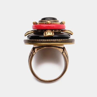 Bague fantaisie "Merveille d'Antan" avec empilement de cabochons noirs et rouges, détails dorés et monture bronze.
