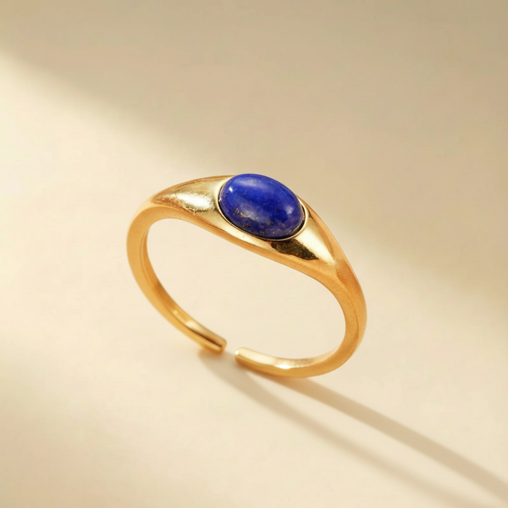 Bague ajustable en argent plaqué or, ornée d'une pierre ovale de lapis-lazuli bleu profond au centre, style minimaliste.