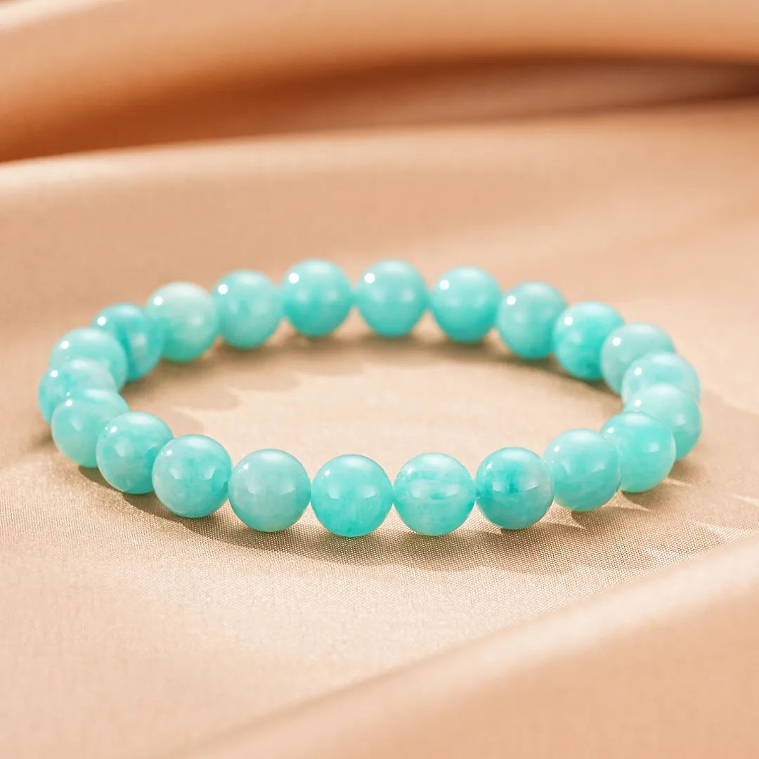 Bracelet "Fraîcheur Douce" en amazonite avec des perles rondes bleu turquoise sur fond satiné.
