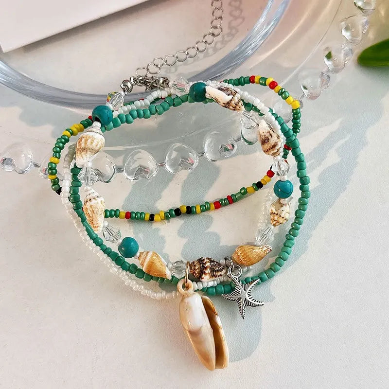 Ensemble de bracelets de cheville "Mer Profonde" ornés de coquillages, perles colorées et breloques étoile de mer.