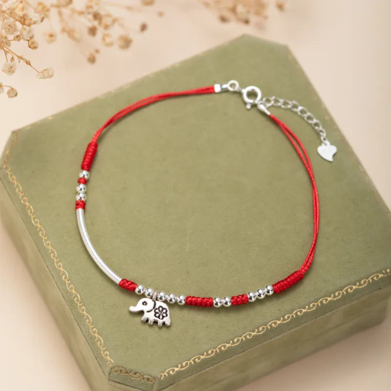 Bracelet de cheville "Petite Éléphant" en argent avec cordon rouge et perles argentées.