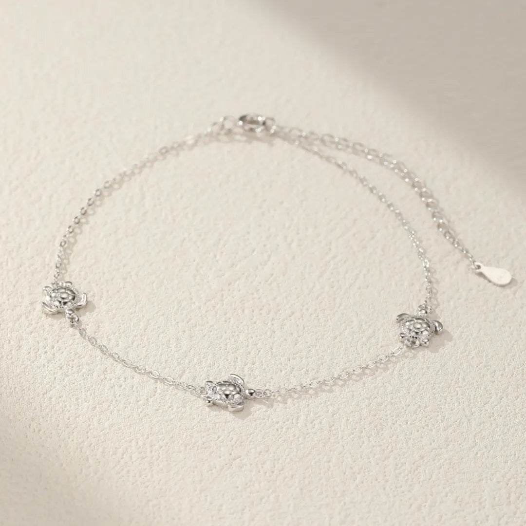 Bracelet de cheville en argent 925 avec des petites tortues incrustées de zircons cubiques, chaîne fine et ajustable.