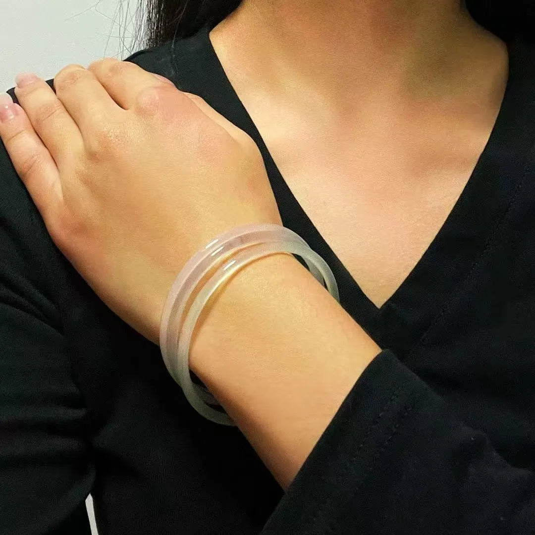 Bracelet jonc en calcédoine "Fraîcheur Aquatique" porté par une femme sur son poignet, le bracelet est transparent avec des reflets bleutés.