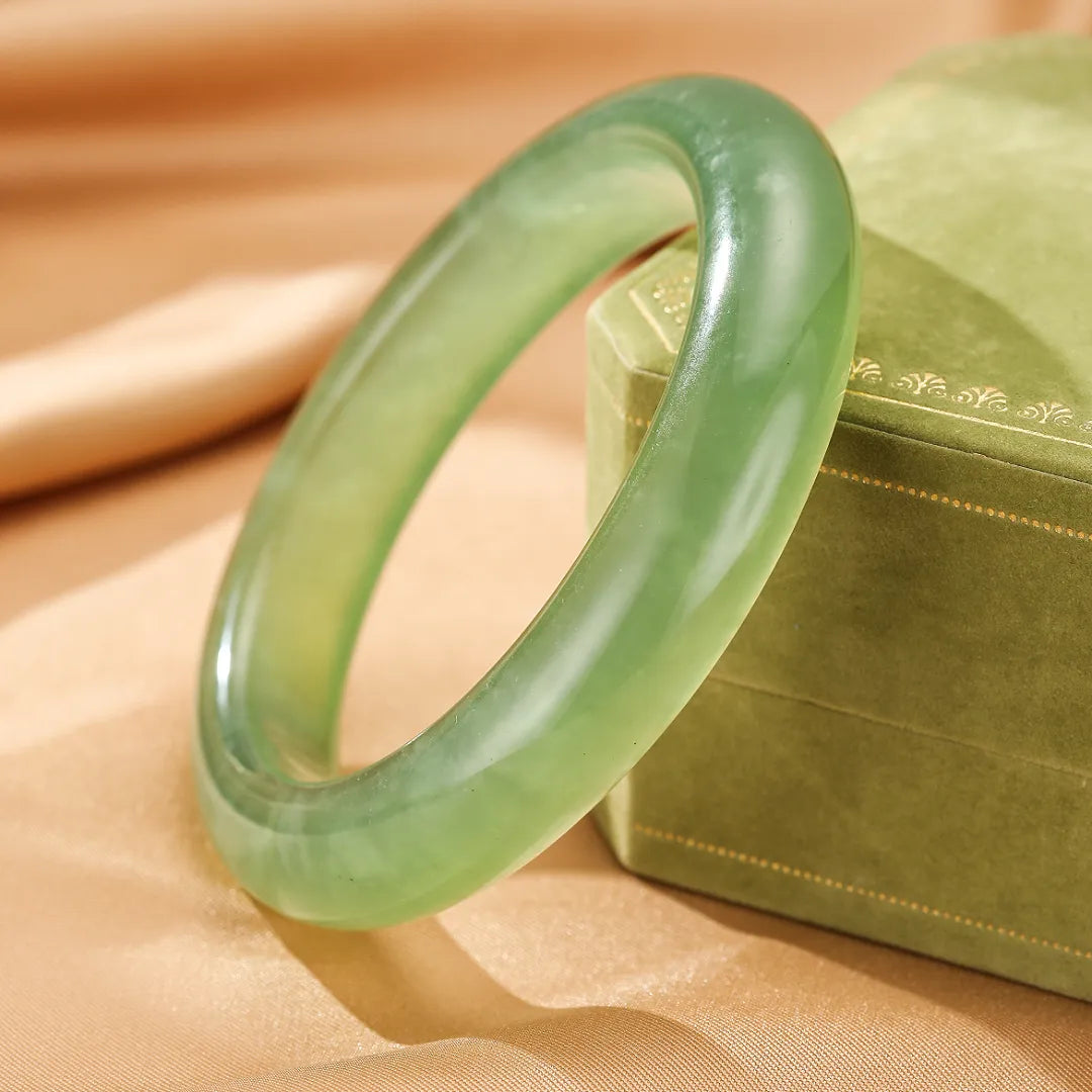 Bracelet jonc en jade vert pâle, nom "Puissance Tranquille", posé sur un écrin vert.