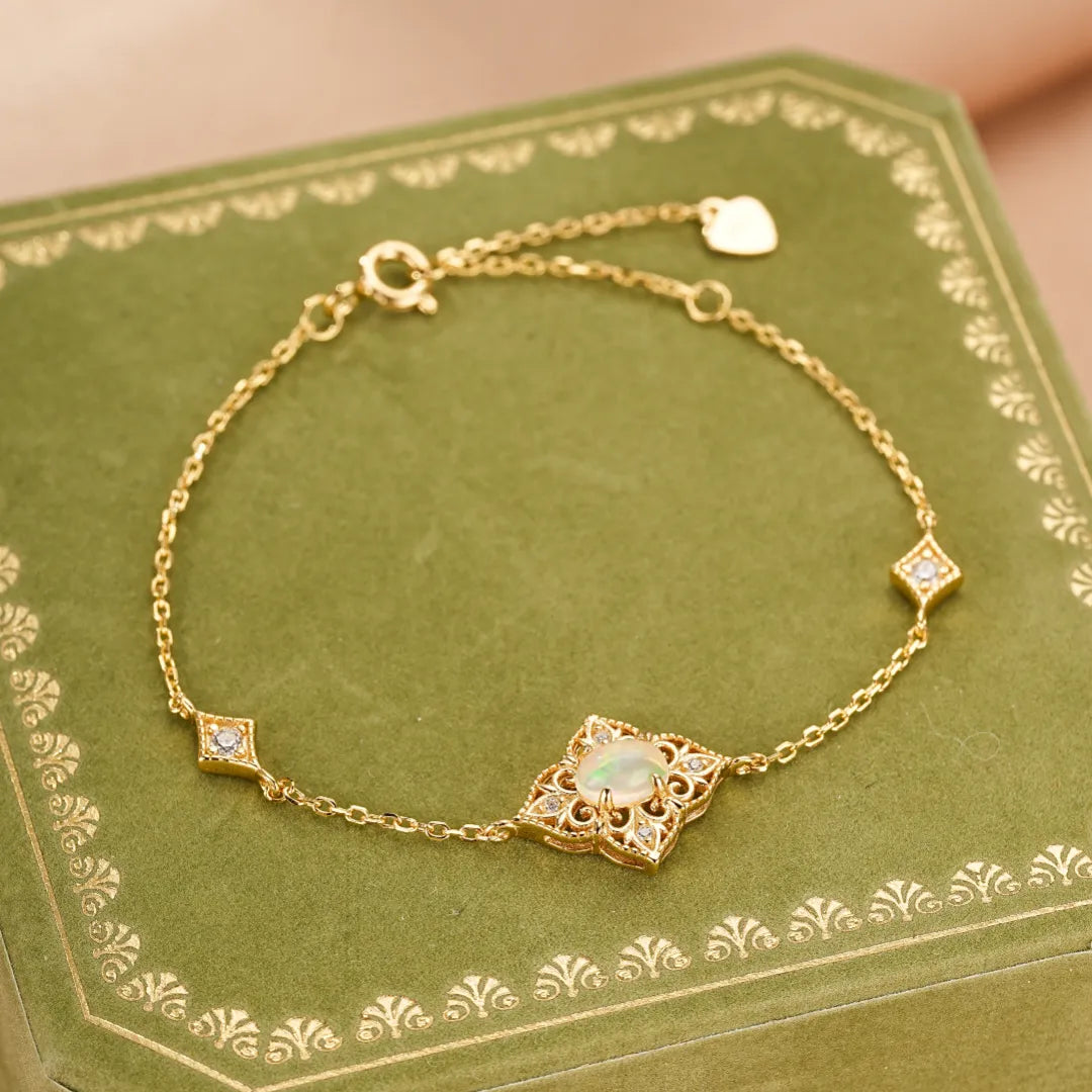 Bracelet "Lumière Antique" en argent doré à l'or 10K, orné d'une opale centrale dans un motif ajouré et de petits diamants sur les côtés.