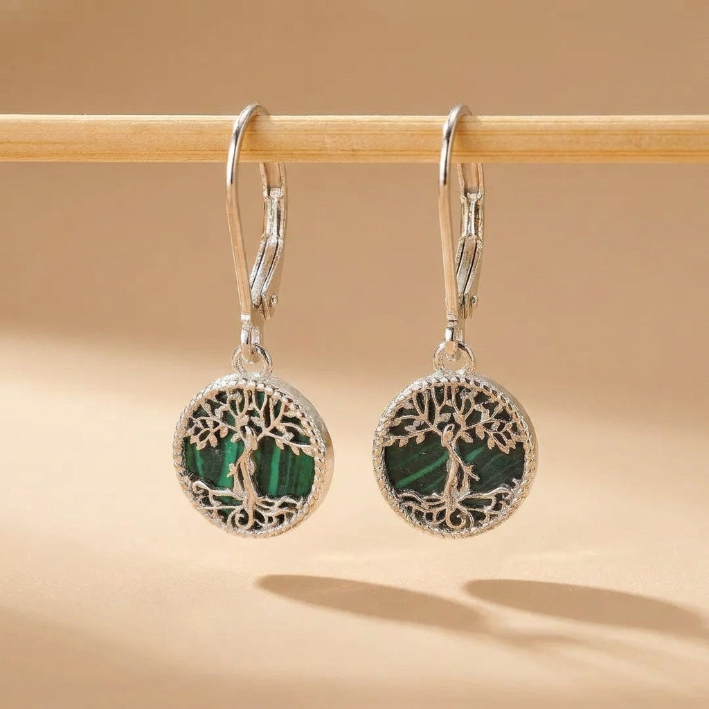 Boucles d'oreilles argentées avec un motif d'arbre de vie ajouré encadrant une pierre de malachite verte striée. Style pendant avec fermoir crochet. @main