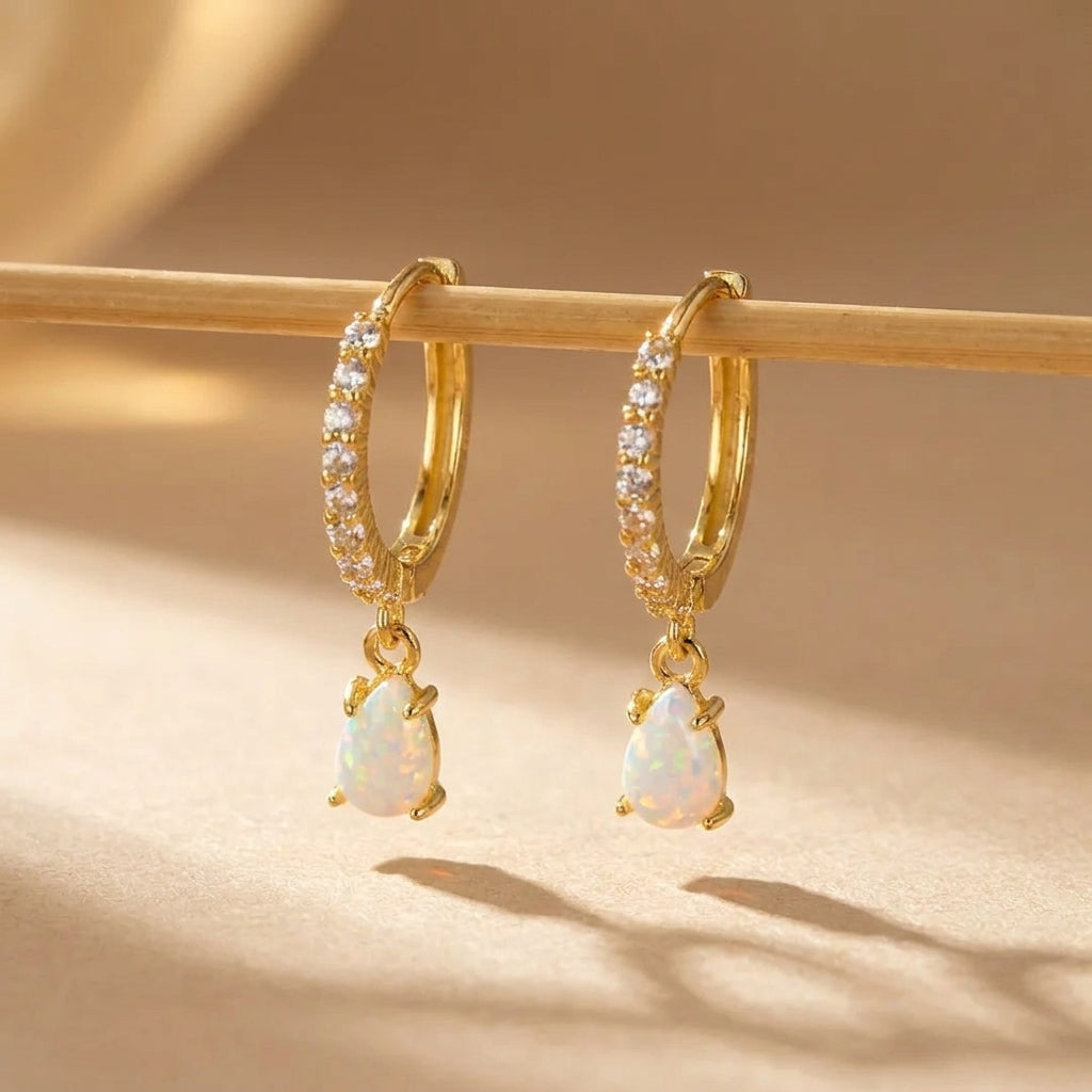 Boucles d'oreilles créoles plaquées or avec opale blanche en forme de larme et zircons cubiques @main