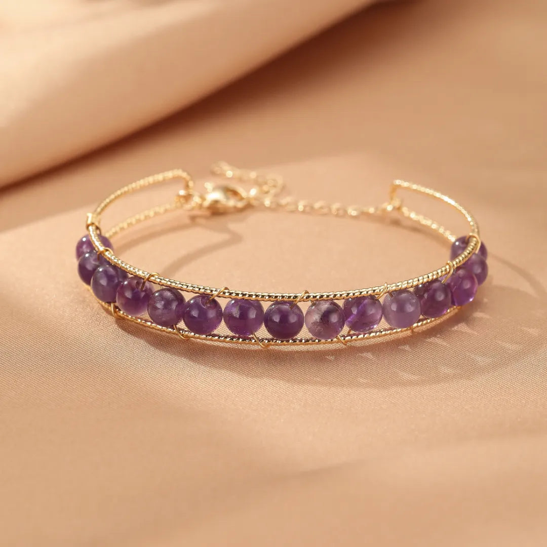 Bracelet en pierres d'améthyste facetées montées sur un fil doré, bijou de la collection "Énergie Douce".