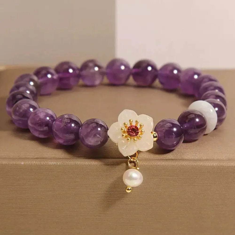 Bracelet "Fleur d'Harmonie" en améthyste, jade blanc et perle avec un pendentif fleur orné de pierres roses et dorées.