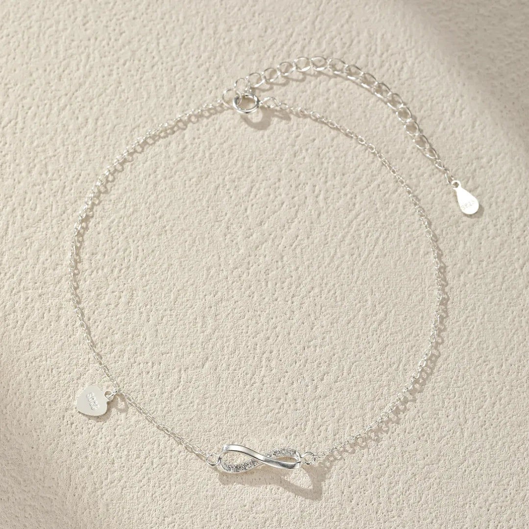 Bracelet de cheville en argent 925 orné d'un symbole infini serti de zircons et d'un petit cœur gravé.