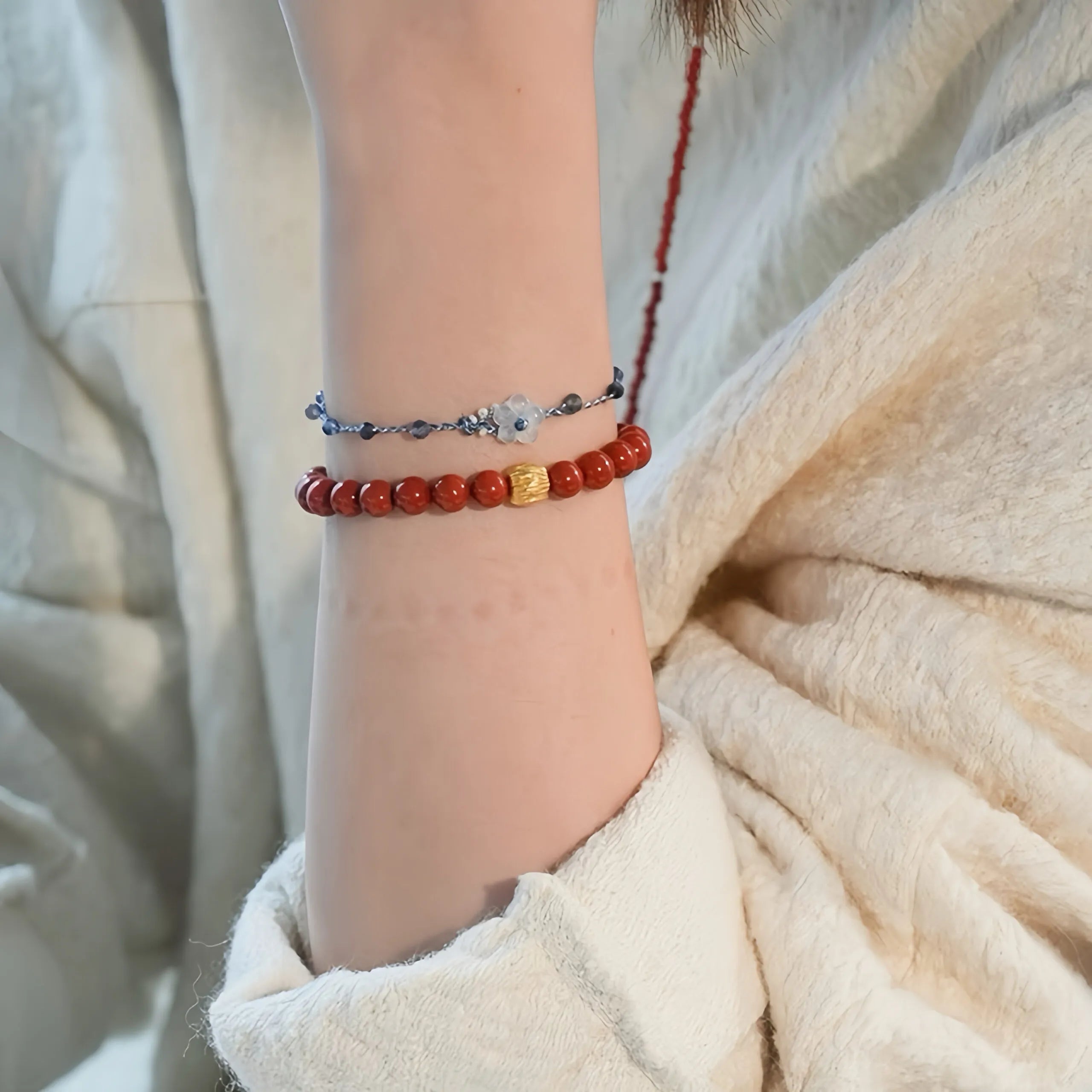 Gros plan sur le Bracelet en Agate Rouge, mettant en évidence la texture unique des perles et l'éclat du plaquage or.