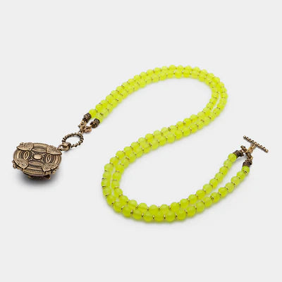 Collier double rang de perles rondes en agate jaune vif, orné d'un fermoir mousqueton et d'un pendentif ovale ouvragé couleur bronze.
