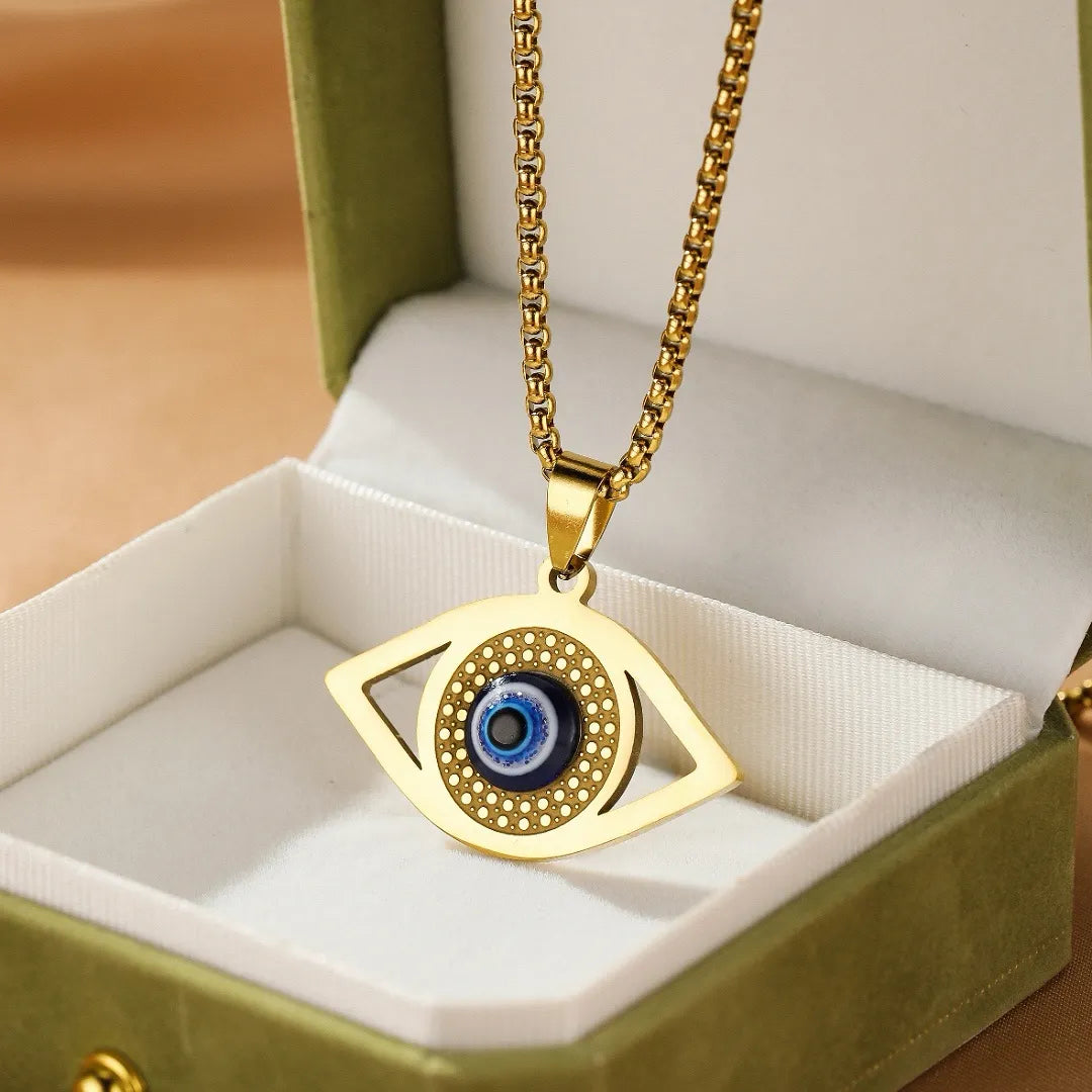 Collier Mauvais Œil Protection Lumineuse en or avec pendentif œil bleu et chaîne en maille cubique dans une boîte cadeau verte.