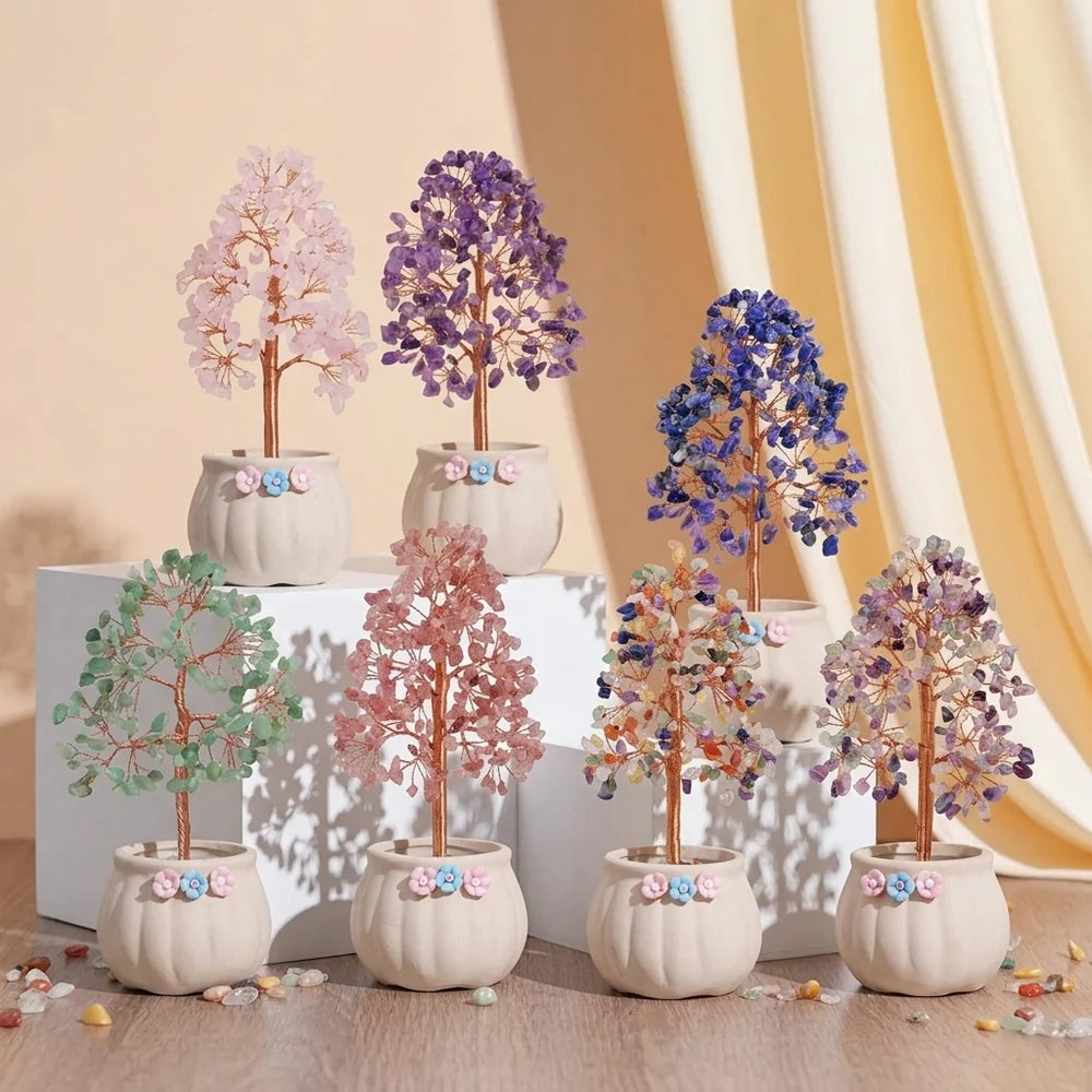 Un ensemble de sept arbres de vie décoratifs en pierres naturelles de différentes couleurs, tels que le rose, le violet, le bleu, le vert et multicolore, disposés dans des pots blancs ornés de fleurs roses et bleues.