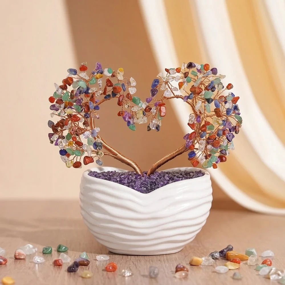 Arbre de vie en forme de cœur fait de pierres semi-précieuses multicolores et de fil de cuivre, planté dans un pot blanc rempli d'améthyste, sur un fond beige