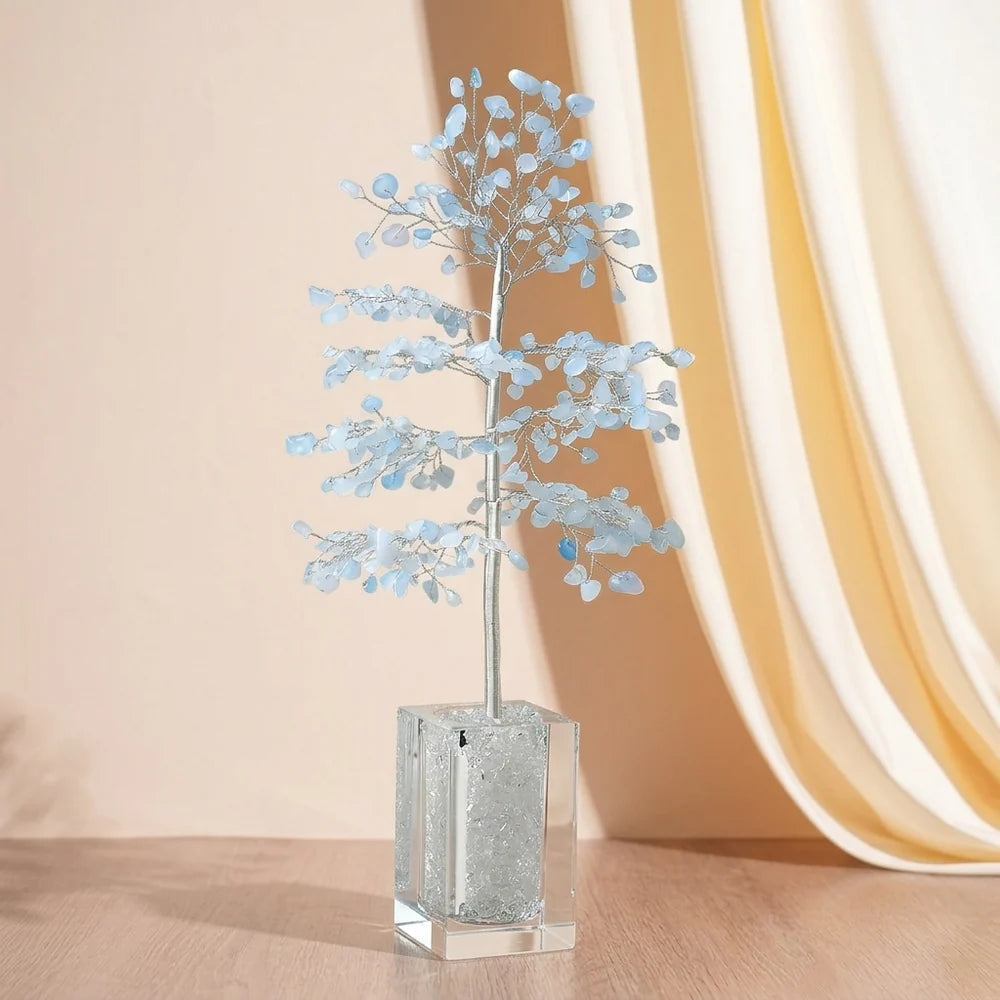Arbre de Vie "Sérénité Céleste" en Aigue-marine avec un socle en cristal transparent rempli de cristaux.